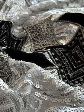Silver sequins and black velvet patches on an organdy ground